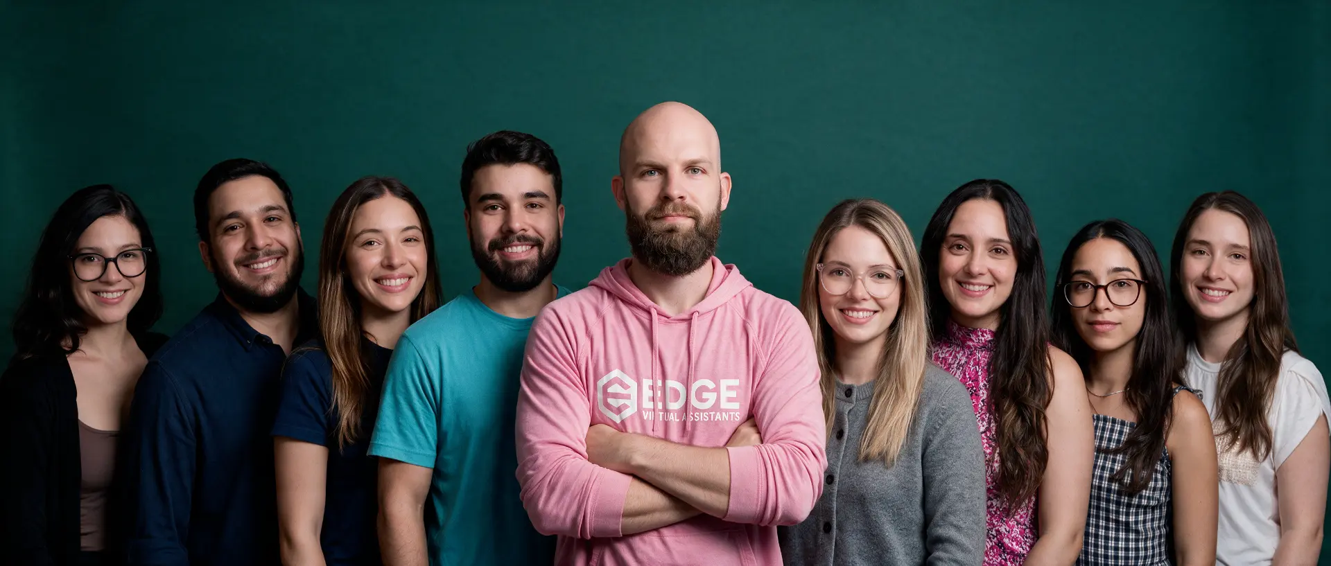The Edge team standing together in front of a deep green backdrop